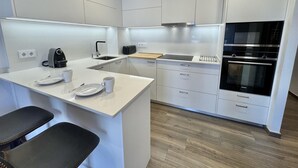 Een moderne keuken met een vast geïntegreerd kookeiland, een koffieapparaat, een broodrooster en een Siemens oven.