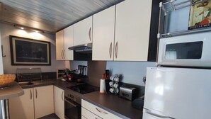 Eine moderne Küche mit weißen Schränken, einem eingebauten Backofen, einem Herd und einem weißen Kühlschrank.