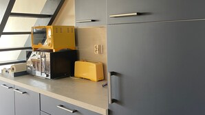 A kitchen with a microwave, toaster, and cabinets. - Bright apartment near the beach - 6 guests (Arzon)