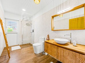 Une salle de bain moderne équipée d’une douche, de toilettes et d’un meuble-lavabo.