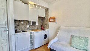 A compact kitchen with a washing machine, a microwave, and a sink. - Cozy Apartment with Pool and Terrace in Puig Rom, 2km from Roses Beach - Sleeps 4 (Roses)