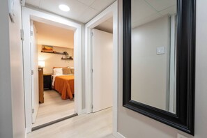 A hotel room with a bed, bedside table, and a nightstand.