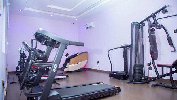 Uma academia com equipamentos de ginástica, incluindo esteiras, bicicleta ergométrica e aparelhos de musculação.