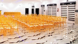 A conference room with rows of yellow chairs, a podium, and a whiteboard. - Great Majesty Hotel  (Nsukka)