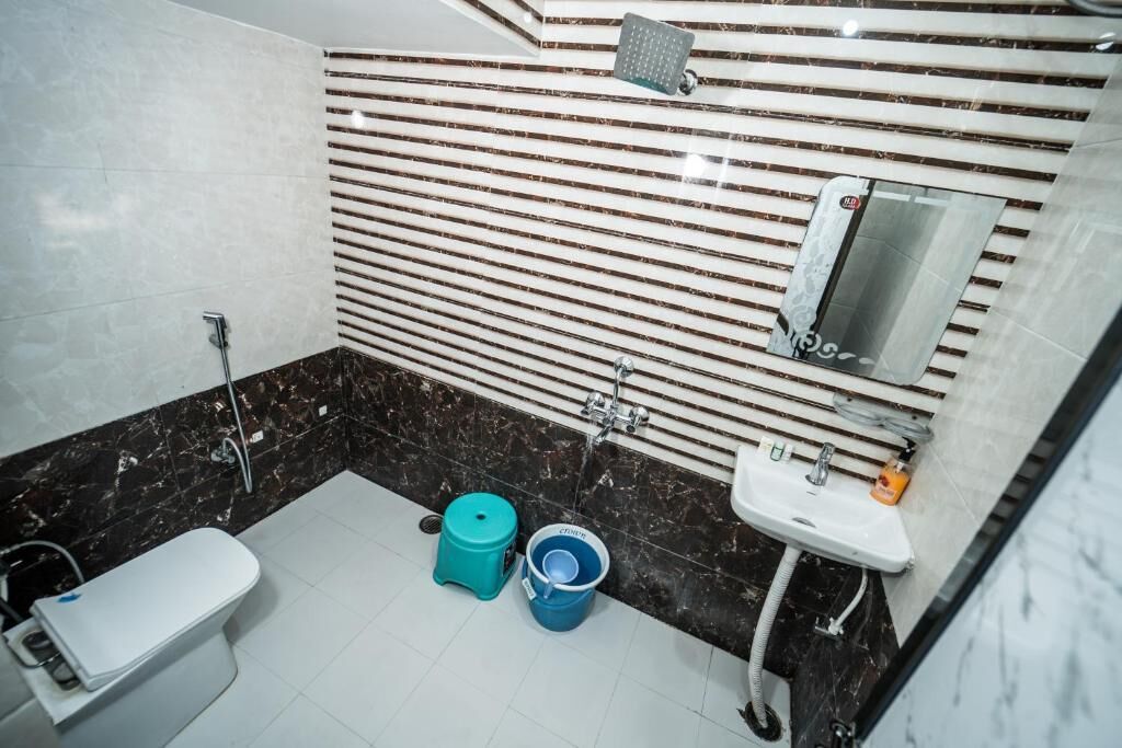 Une salle de bain avec des toilettes, un lavabo et une douche.