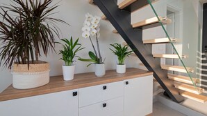 A staircase with a glass railing, a wooden floor, and a white cabinet with drawers. - Villa Amelia by Travel Pro - Mouries Halkidiki (Nea Moudania)