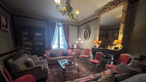 Una sala de estar tradicional con un sofá, sillones, una mesa de centro y una chimenea.