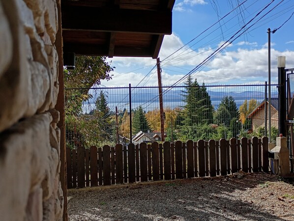Un edificio de piedra con valla de madera y vistas a casas y árboles.
