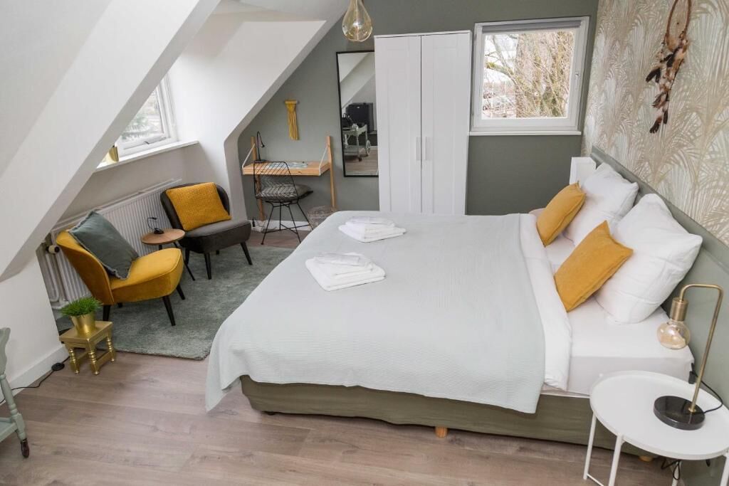 A bedroom with a bed, a desk, a chair, and a wardrobe.