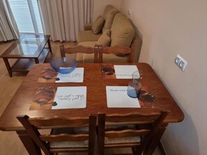 Uma mesa de jantar com quatro cadeiras, uma tigela azul e papéis com anotações manuscritas.
