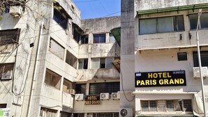 A multi-story building with signs for 'HOTEL PARIS GRAND' and 'SIDDHIENTERPRISE.'
