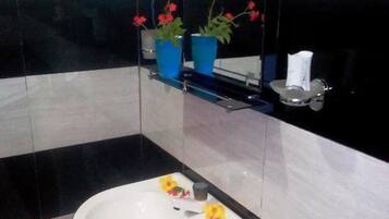 Deluxe tweepersoonskamer, uitzicht op tuin | Badkamer | Een douche, gratis toiletartikelen, een haardroger, handdoeken