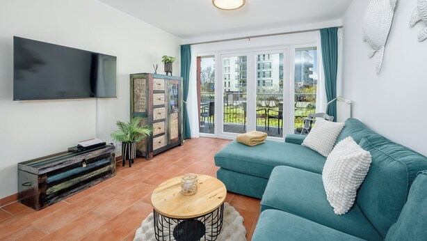 Ein Wohnzimmer mit Flachbildfernseher, Sofa, Couchtisch und Schrank.
