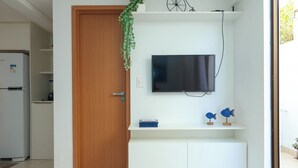 Et moderne køkken med indbygget TV, en trædør og en lille hylde med pynt.