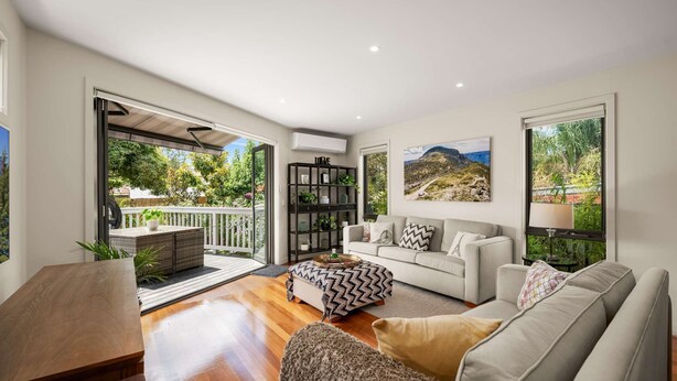 A modern living room with a sofa, a coffee table, and a bookshelf.