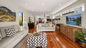 A spacious living area with a sofa, coffee table, and a view of a mountain landscape.