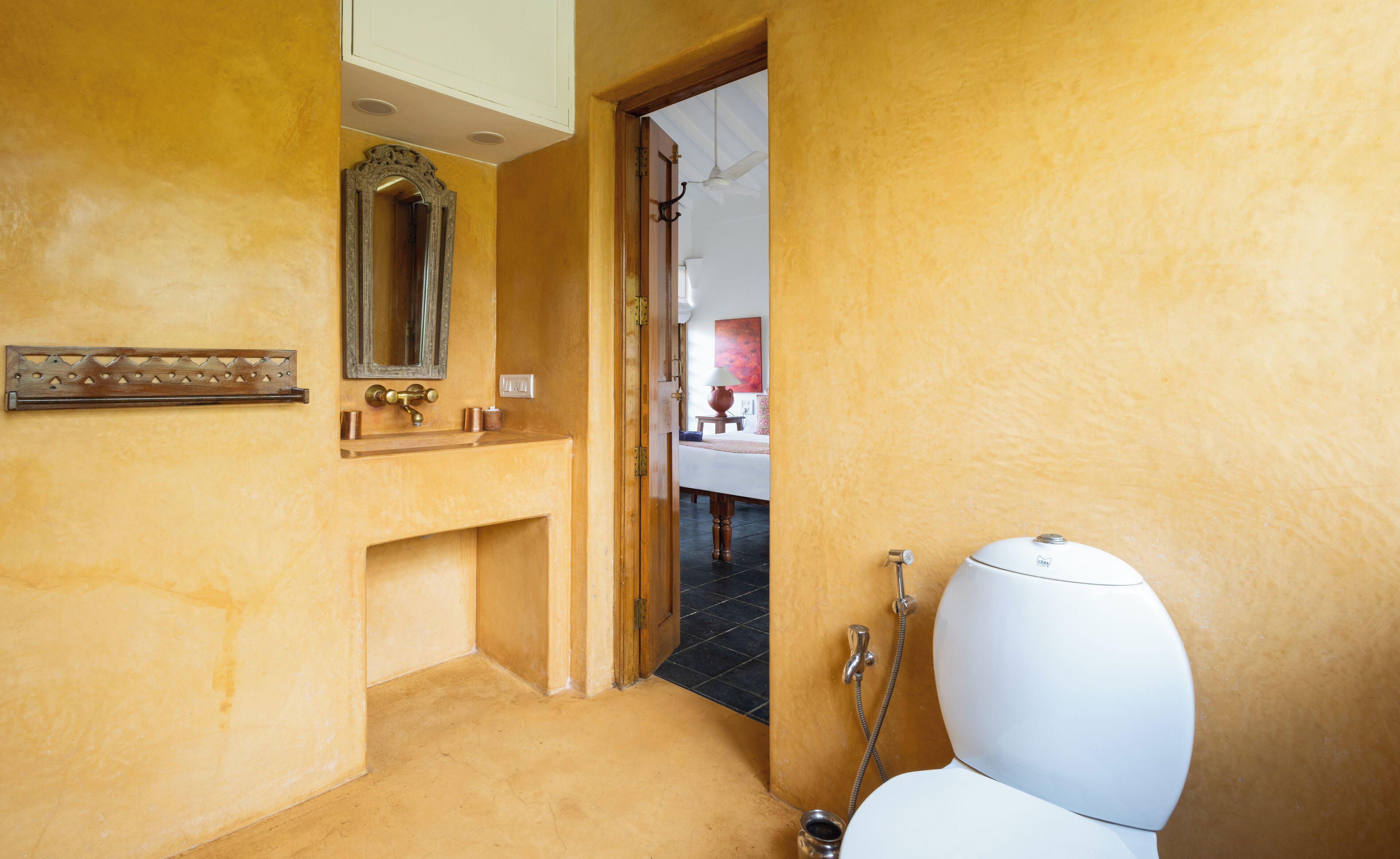 Un baño con inodoro, lavamanos y espejo.