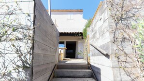 A narrow wooden staircase leading to a building entrance with a tiled roof and a small window. - STUNNING APARTMENT (Sainte-Maxime)