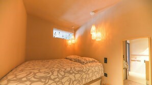 A bedroom with a bed, a window, and hanging light fixtures. - STUNNING APARTMENT (Sainte-Maxime)