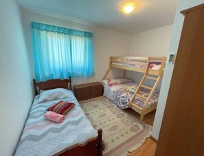 A bedroom with a single bed, a bunk bed, a nightstand, a dresser, and a window with curtains. - Relaxing Getaway Near Adriatic Sea (Marcana)