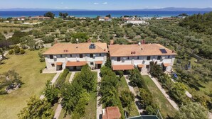 Un complejo residencial con edificios de dos plantas, paneles solares y vista al mar.