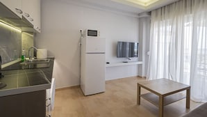 Una cucina moderna con forno a incasso, frigorifero e televisore a schermo piatto montato a parete.