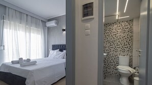 Una camera da letto con un letto, un bagno con il water e la doccia, e un corridoio con una porta.