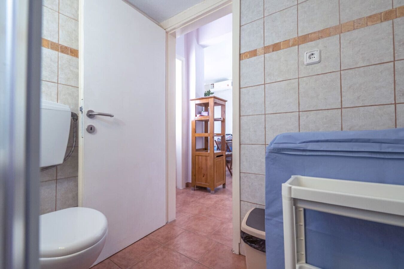 A bathroom with a toilet, a shower, and a sink.