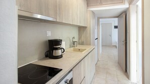 Une cuisine moderne équipée d’une cuisinière intégrée, d’une machine à café et d’un évier.