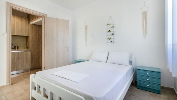 Une chambre à coucher comprenant un lit, une table de chevet, une armoire et une plante fixée au mur.