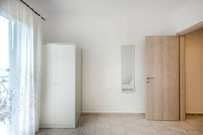 A room with a wardrobe, a mirror, and a door. - Filia Apartment Avgerinos by RentalsPro (Nea Fokea)