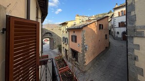 A narrow street with traditional architecture, a stone bridge, and a clear sky. - Lovely apartment for 3 people with WIFI, A/C, terrace, pets allowed and panoramic view (Cortona)