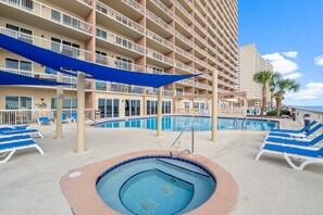 A hotel with a large pool area, multiple balconies, and lounge chairs. - NEW Sunrise Beach 510! FREE Beach Service, Heated Pool, FREE Golf & Perks! (Panama City Beach)