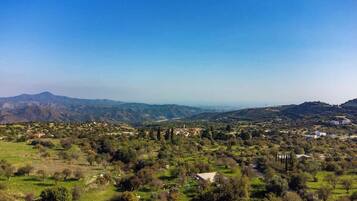 Panoramica di un paesaggio montuoso con edifici sparsi e vegetazione.