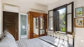 Ein Schlafzimmer mit Bett, Kleiderschrank, Tür und Fenster mit Blick.