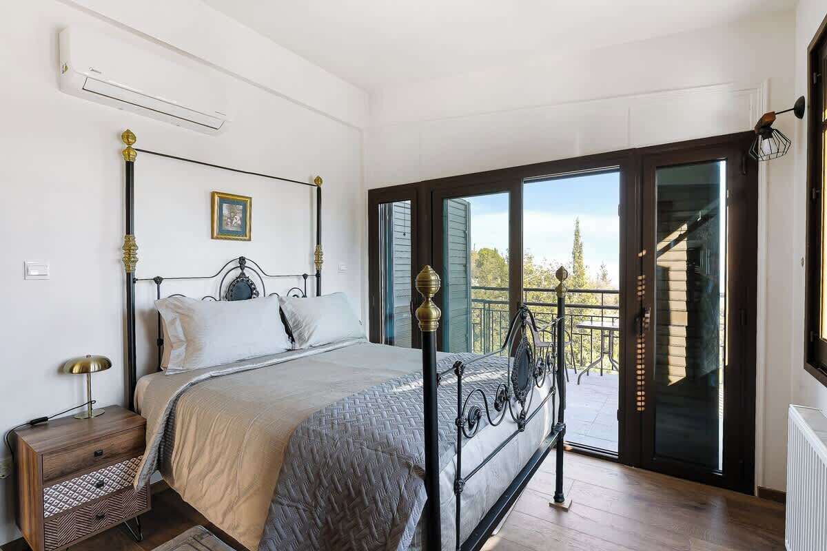 Una camera da letto con un letto, un comodino, una finestra e un balcone.