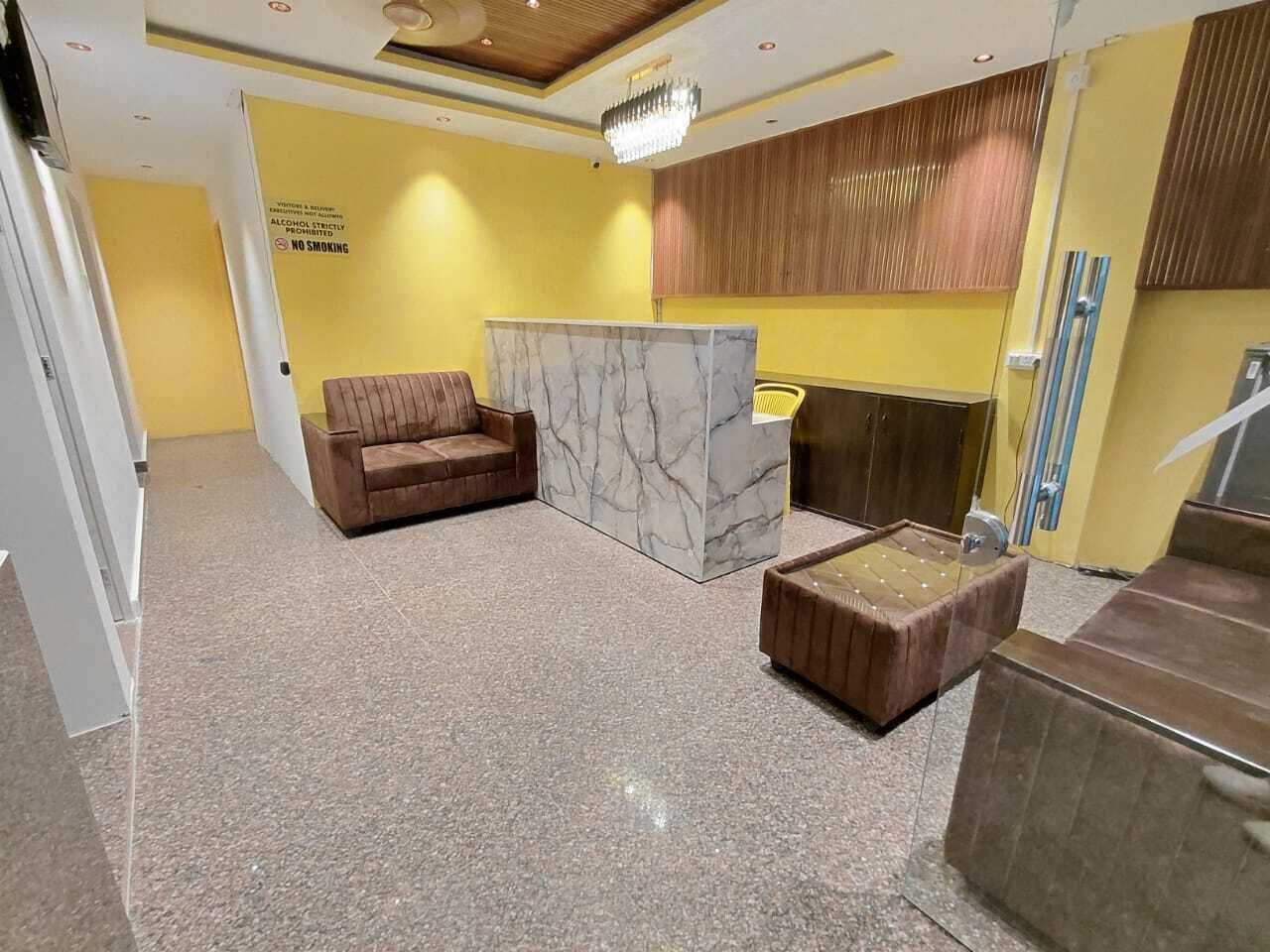 A lobby with a marble reception desk, a brown leather sofa, and a wooden bench.