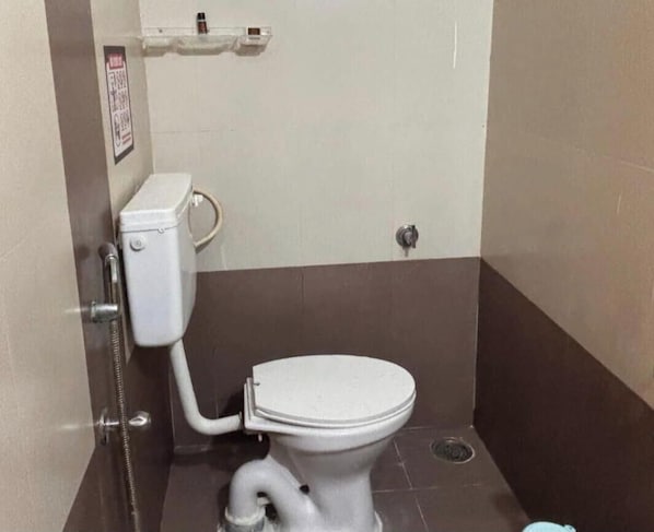 A bathroom with a toilet, a shower, and a hand dryer.