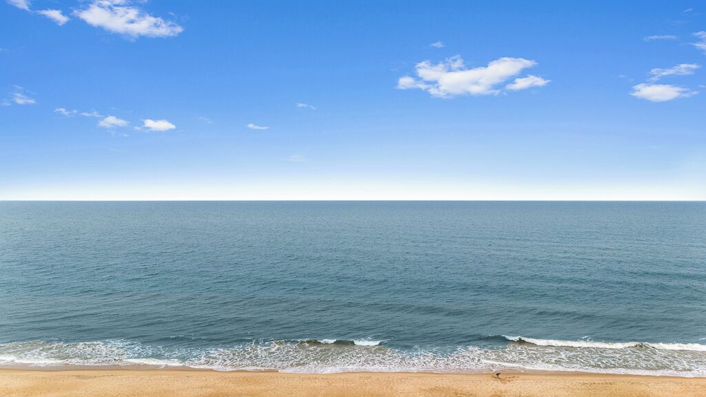 Ein Strand mit klarem Himmel und ruhiger See.