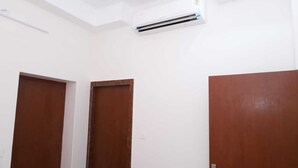 A room with two wooden doors, a white ceiling, and an air conditioning unit. - Hotel Mahadev Residency Jaisalmer (Jaisalmer)