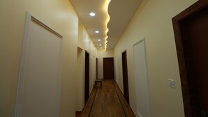 A hallway with a wooden floor, white walls, and a ceiling with recessed lighting. - Hotel Mahadev Residency Jaisalmer (Jaisalmer)