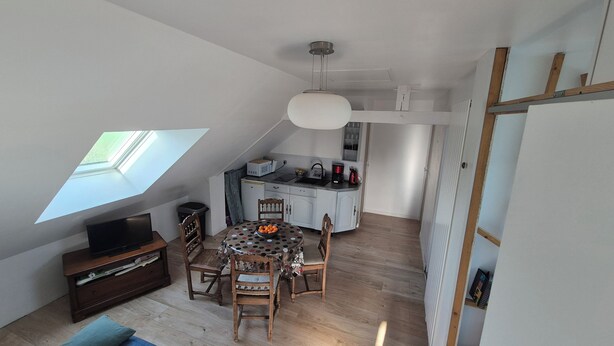 A compact, modern loft with a dining area, kitchenette, and a skylight. - Cosy gîte upstairs (Sainte-Anne-sur-Vilaine)