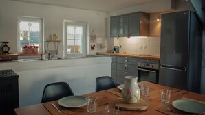 A kitchen with a dining table, chairs, a refrigerator, and cabinets. - House 5 minutes from Amboise (Chargé)