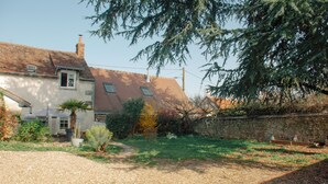 A house with a sloped roof, a gravel driveway, and a stone wall. - House 5 minutes from Amboise (Chargé)