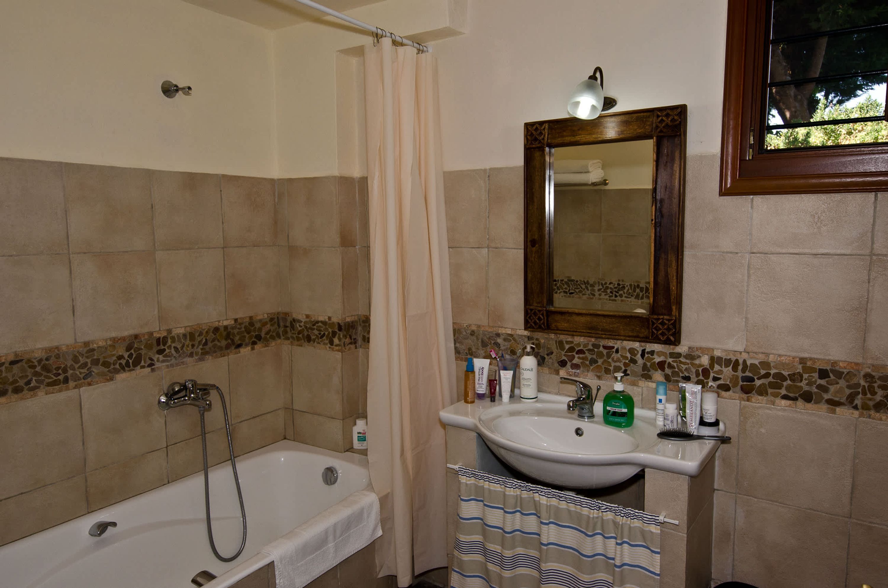 A bathroom with a bathtub, a sink, and a mirror.