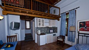 A compact room with a kitchenette, a dining area, a bed, and a staircase leading to an upper level. - Stolios Skopelos - Terpsichore Split Level Nest (Skopelos)