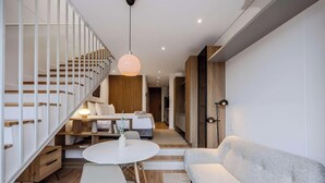 Um interior moderno com escada, sala de jantar e sala de estar.