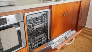 Una cocina con lavavajillas Bosch, cafetera y armarios de madera.