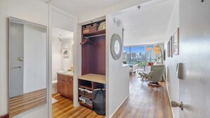 Un interior moderno con suelo de madera, balcón con vistas a la ciudad y diseño minimalista.