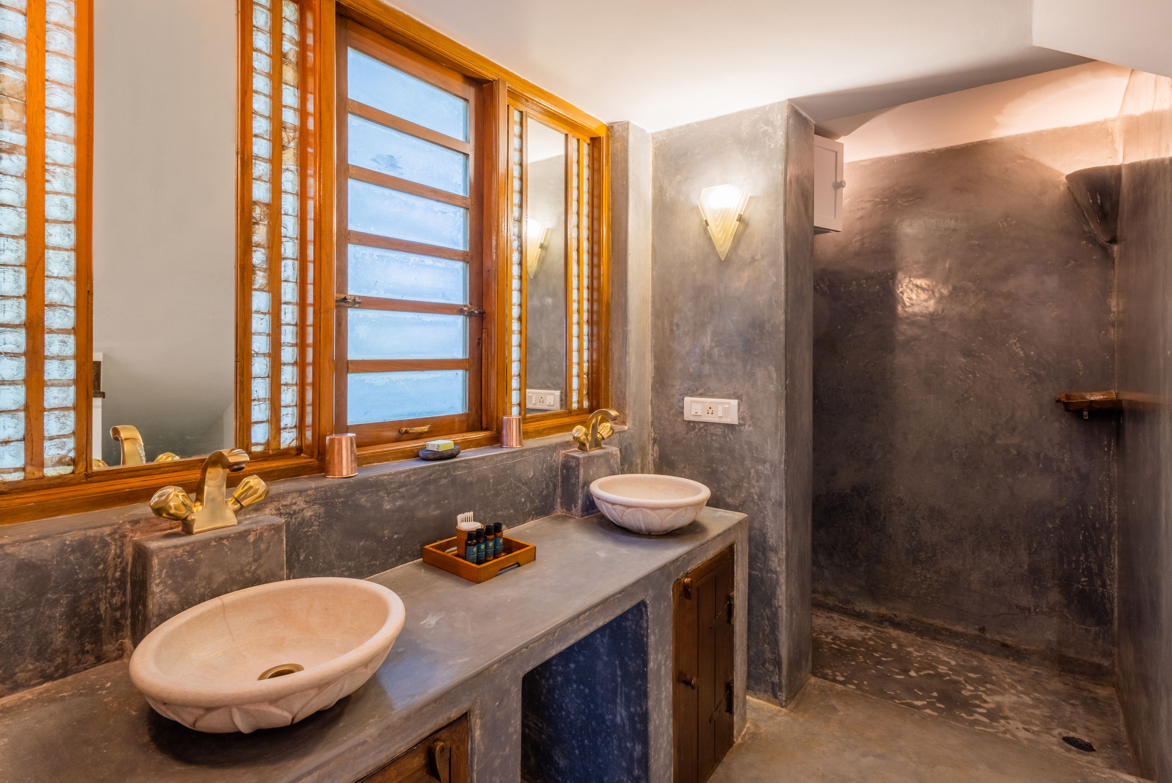A bathroom with two sinks, a window, and a shower.